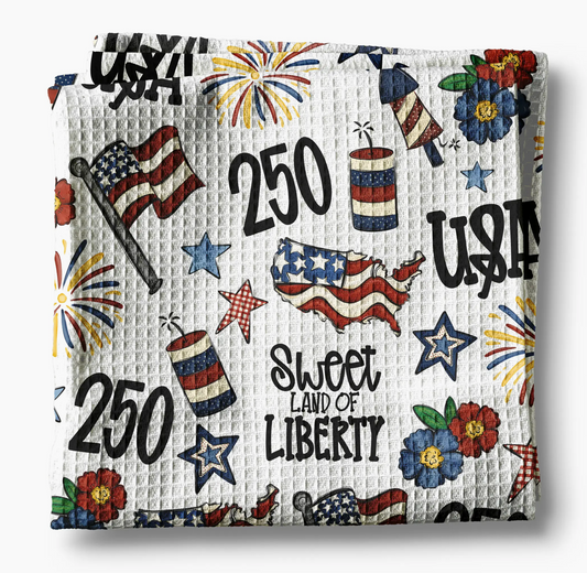 Decorative blanket with American-themed patterns including stars, stripes, and 'Sweet Land of Liberty' text.