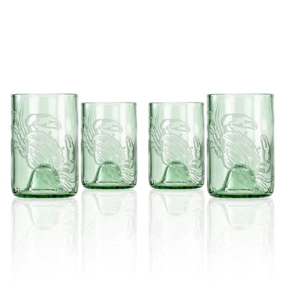 Set of four green glass tumblers with embossed design on a white background