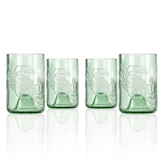 Set of four green glass tumblers with embossed design on a white background