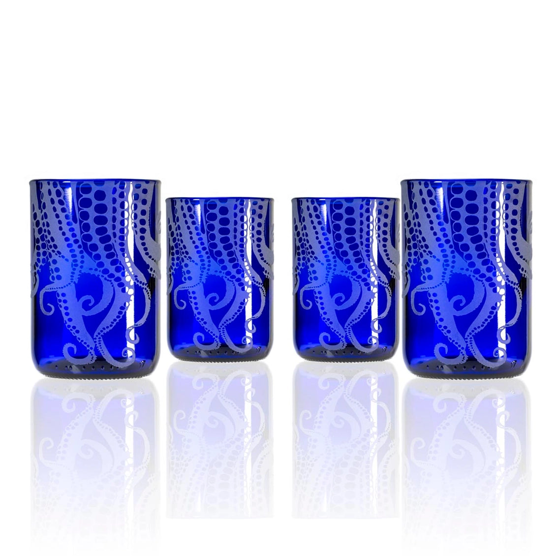 Set of four blue glass tumblers with white patterns on a white background