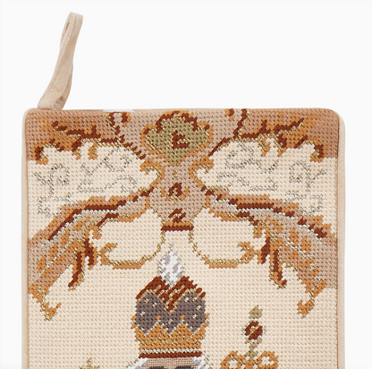 Close-up of ivory nutcracker needlepoint Christmas stocking with decorative bows, ribbon details and metallic gold accents