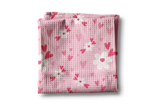 Folded pink fabric with heart pattern on a white background