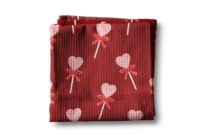 Red textured fabric with heart and bow pattern on a white background