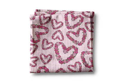 Folded pink fabric with heart pattern on a white background
