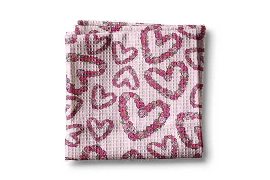 Folded pink fabric with heart pattern on a white background