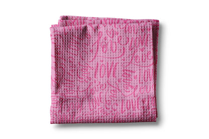 Pink textured towel with text on a white background