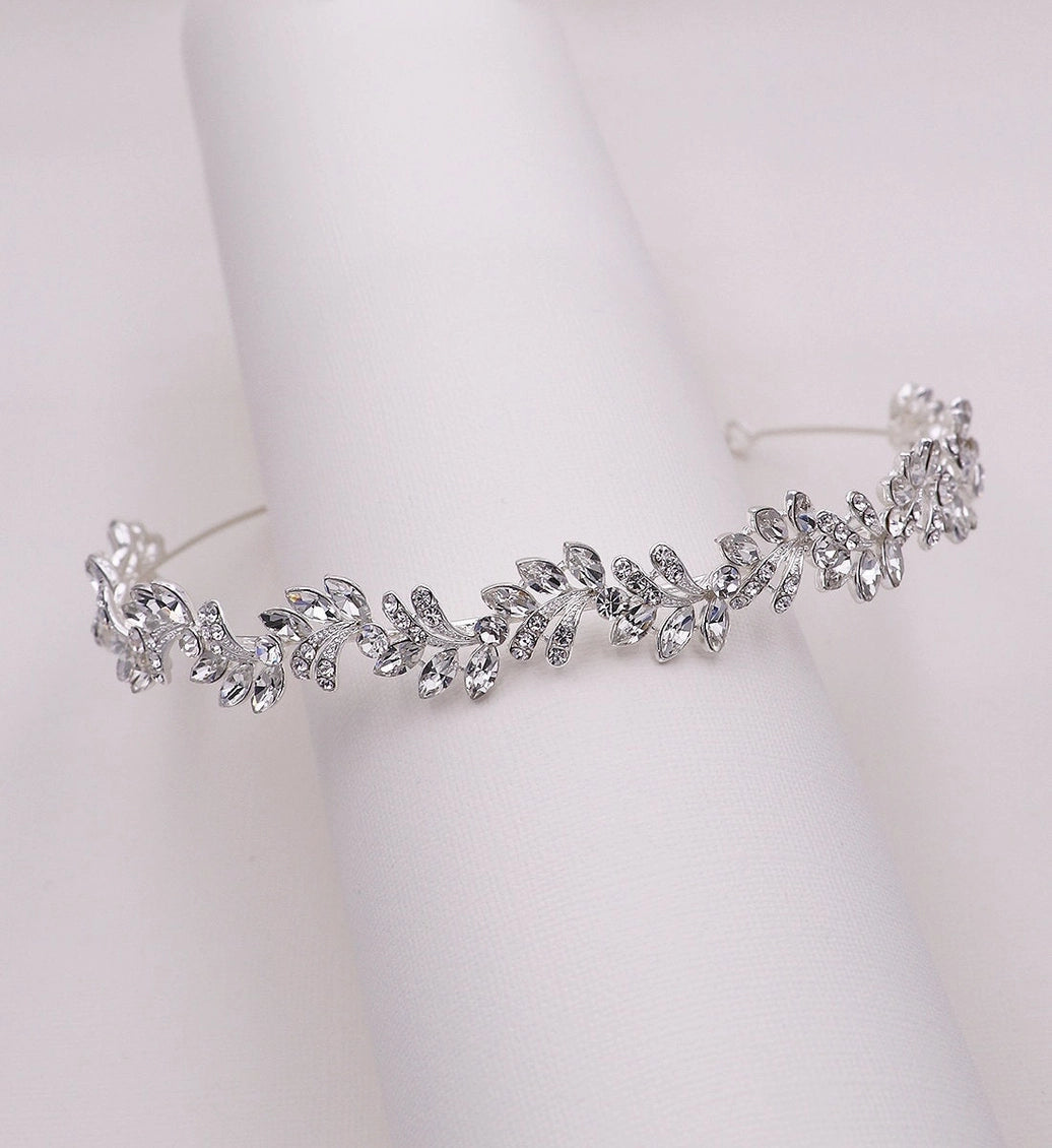 Silver tiara with leaf-like design on a white background