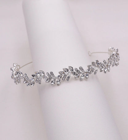 Silver tiara with leaf-like design on a white background