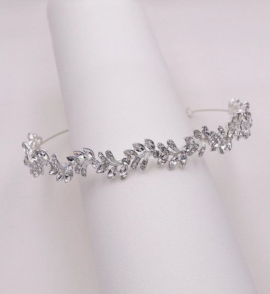 Silver tiara with leaf-like design on a white background