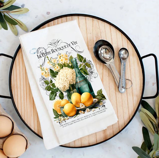 Book titled 'La Petite Boutique de Vin' with lemons and measuring spoons on a wooden board with lemons.