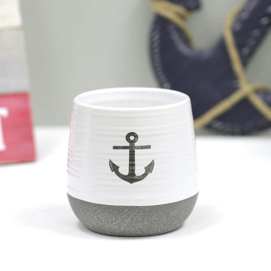 White ceramic cup with gray anchor design on a white background