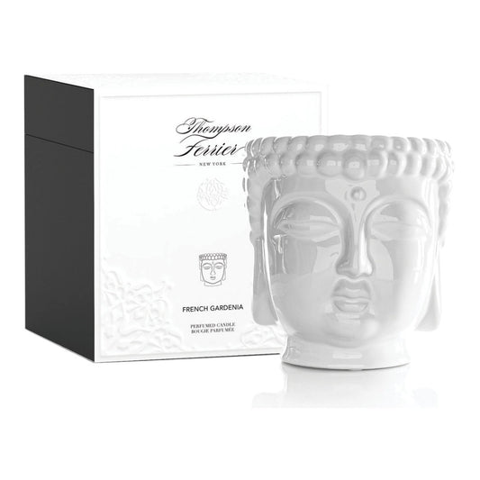 White ceramic face-shaped candle with packaging on a white background