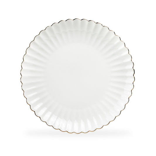 White ceramic plate with scalloped edge on a white background