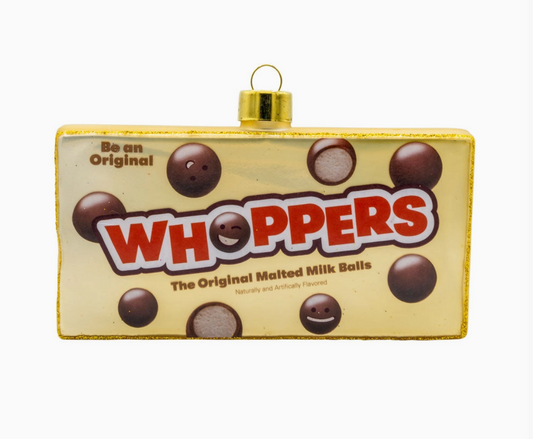 A rectangular gold Christmas ornament styled like a Whoppers candy package, featuring the brand name 'Whoppers' in red and white, chocolate milk balls, and a gold hanging loop at the top, shown on a plain white background.