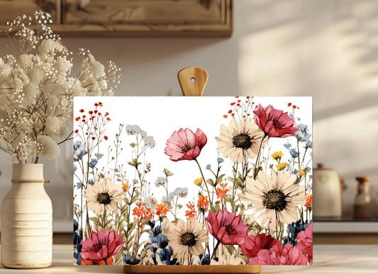Floral painting on a wooden board with a vase of flowers in the background