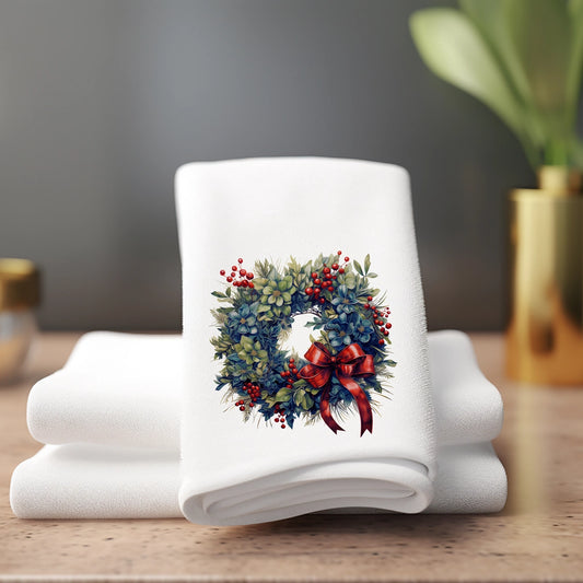 White towel with a festive wreath design on a wooden surface