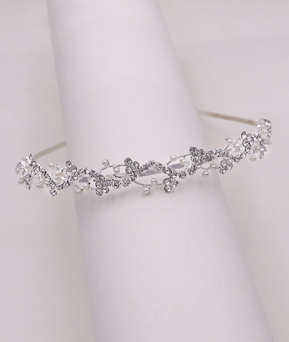 Silver tiara with floral and bead details on a white background
