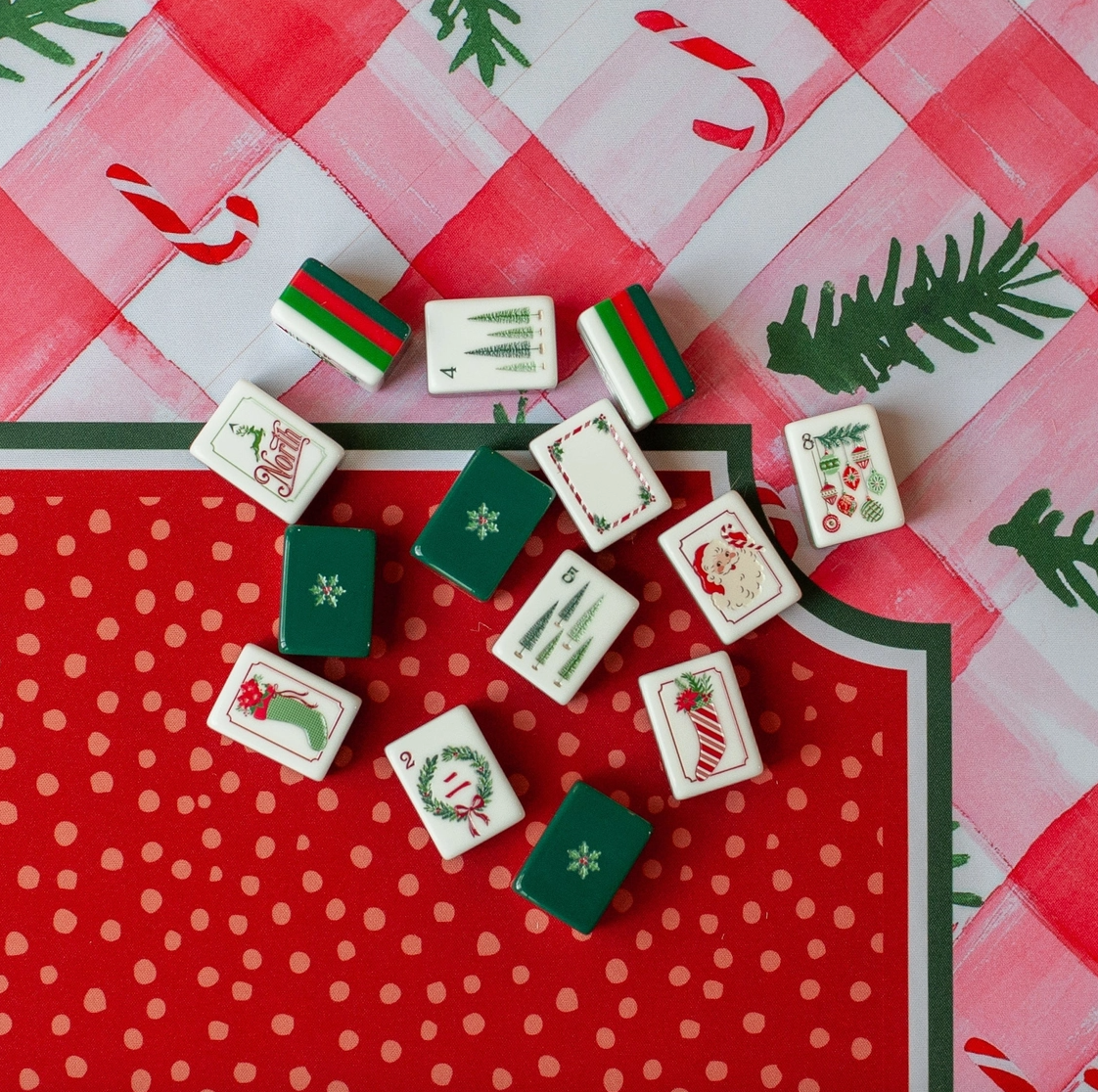 Christmas Mahjong tiles displayed on the Candy Cane Lane Mahjong mat with watercolor gingham, candy canes and evergreen details.