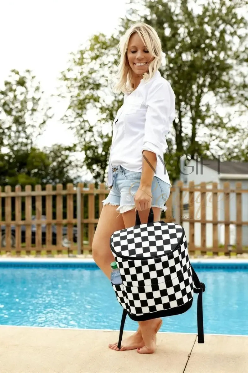 Woman holding a black and white checkered bag by a pool