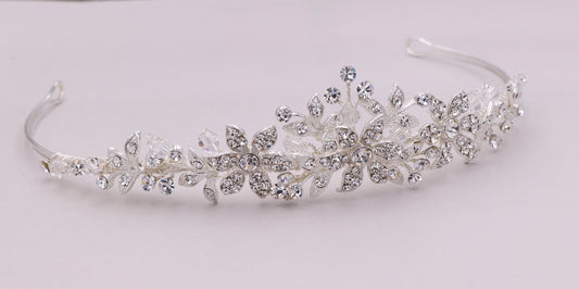 Silver tiara with floral and leaf designs on a white background