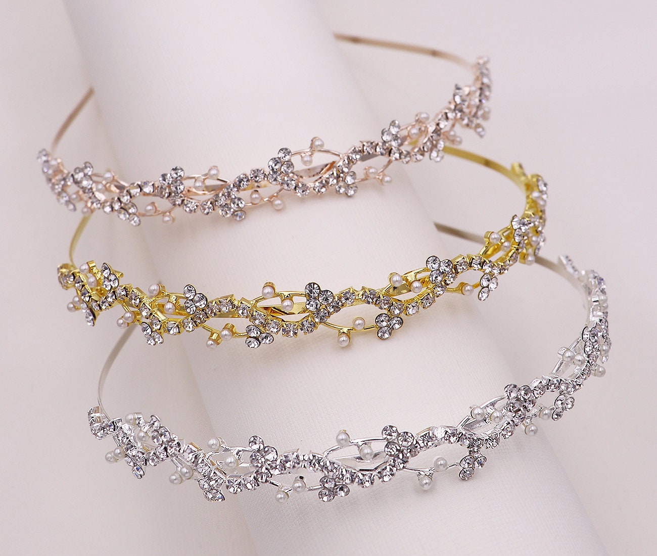 Three decorative headbands with floral designs on a white background