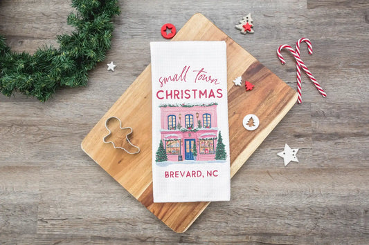 Book titled 'Small Town Christmas Brevard, NC' on a wooden board with Christmas decorations.