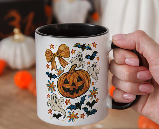 Halloween-themed mug with pumpkins, ghosts, and bats held by a hand.