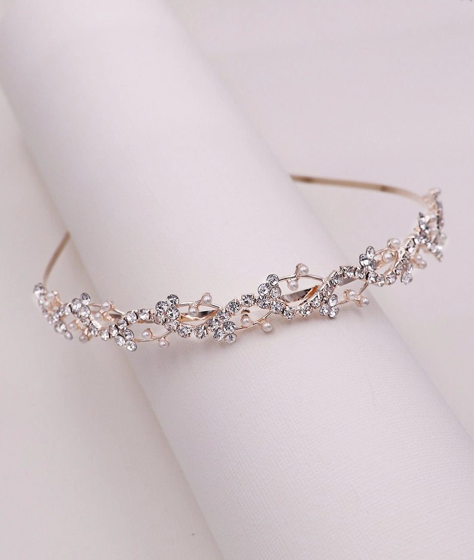 Silver tiara with floral design on a light rose gold background