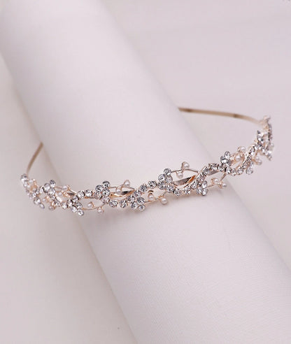 Silver tiara with floral design on a light rose gold background