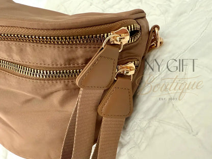 Close-up of a brown bag with gold zippers on a textured white background