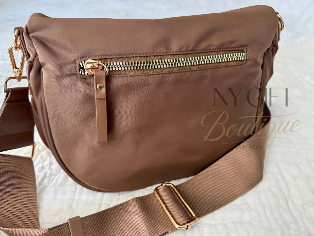 Brown shoulder bag with gold zipper and buckle on a white surface
