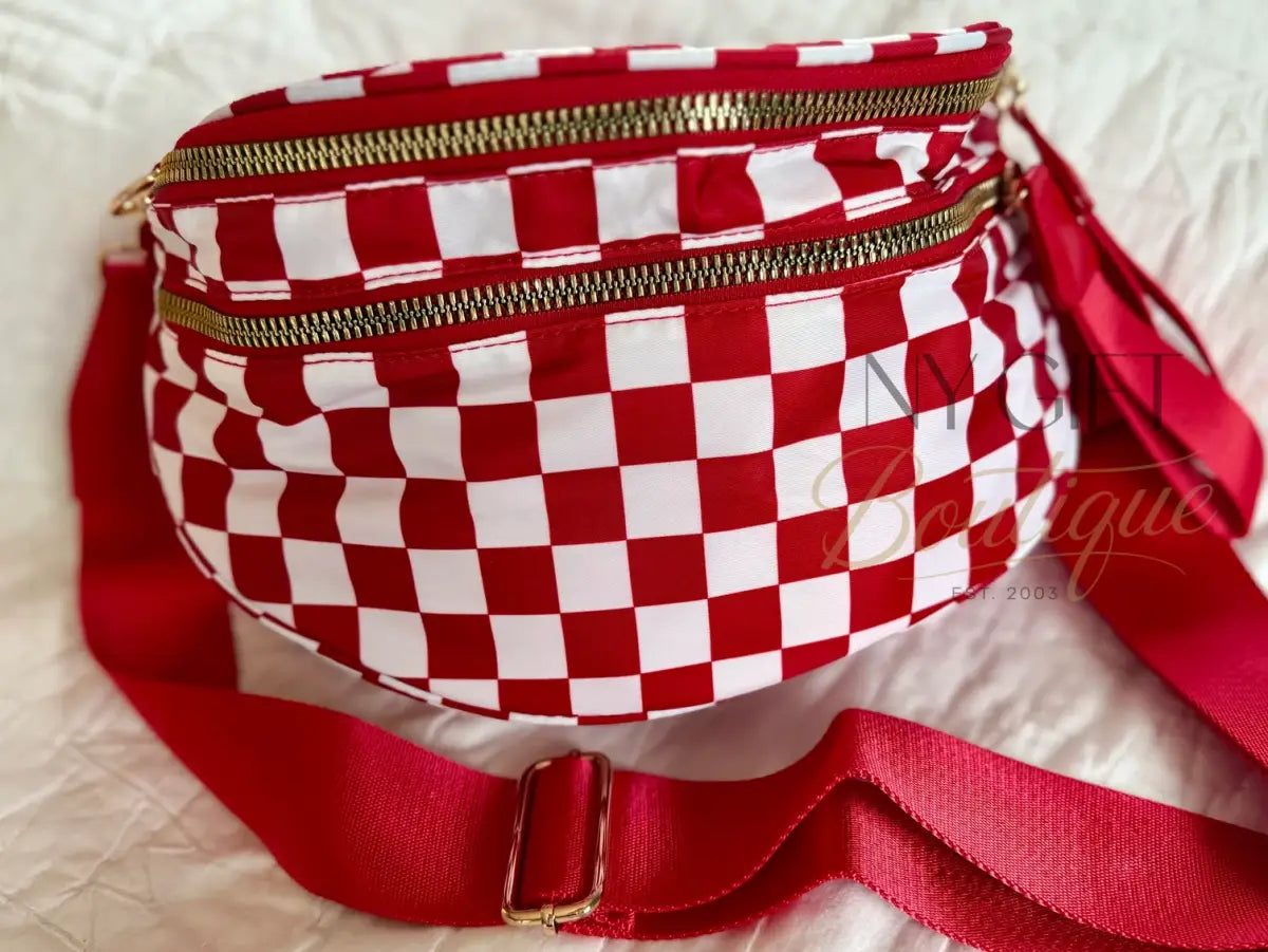 Red and white checkered fanny pack with gold zippers on a light background
