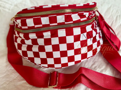 Red and white checkered fanny pack with gold zippers on a light background