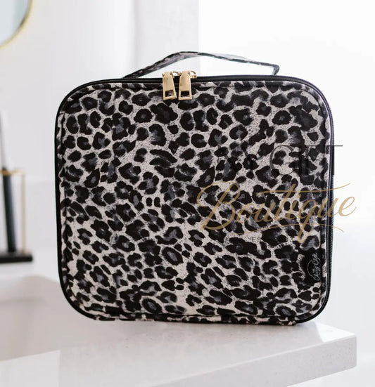 Leopard print makeup bag on a white surface with a blurred background