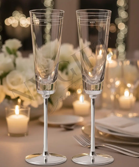 Two clear champagne flutes with silver bases on a white background