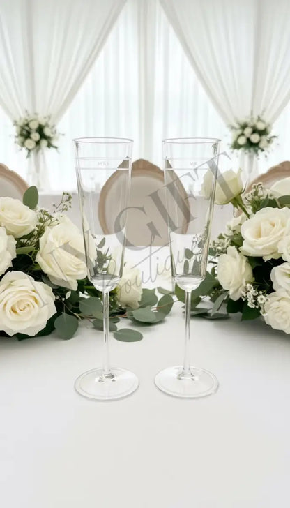 Two champagne flutes with a green box and card featuring 'kate spade' branding on a white background.
